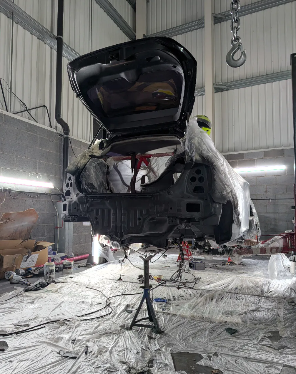 Car body on stand being prepped for underside work